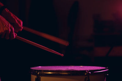 Close-up of man playing piano in dark