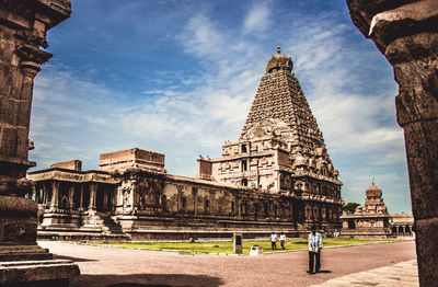 Tourist visiting temple against clear sky