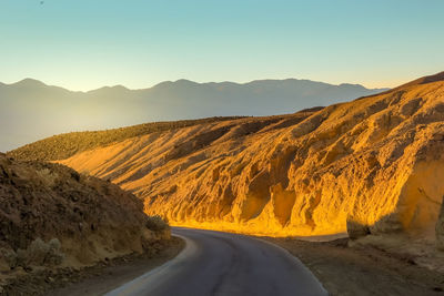 Road amidst desert against clear sky