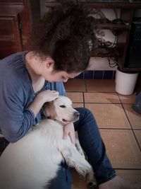 Man with dog sitting at home