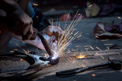 Welding of steel, sparking, not wearing gloves, light colored like fireworks.