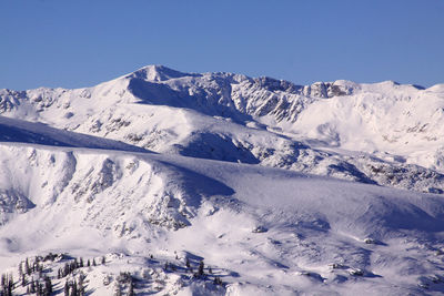 Scenic view of snowcapped mountains against clear sky