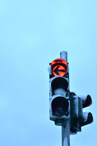 Low angle view of road sign against clear blue sky