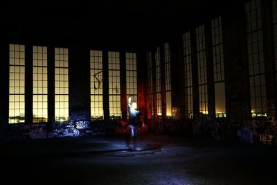 Defocused image of illuminated man standing in abandoned building