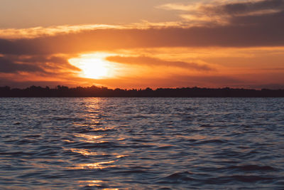 Scenic view of sea against romantic sky at sunset