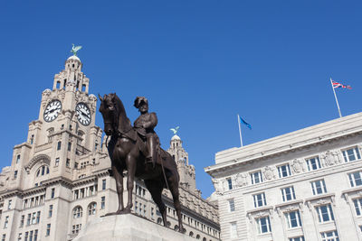 Low angle view of clock tower against blue sky