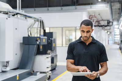 Technician using digital tablet on shop floor in a factory