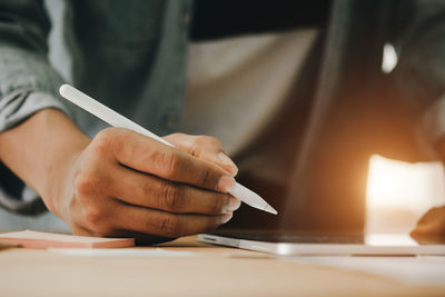 Midsection of man working on table