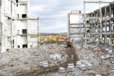 Abandoned construction site by building against sky