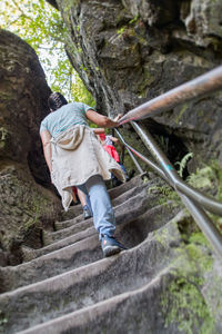 Rear view of woman hiking on rock trail in tha saxon switzerland elbe sandstone mountains