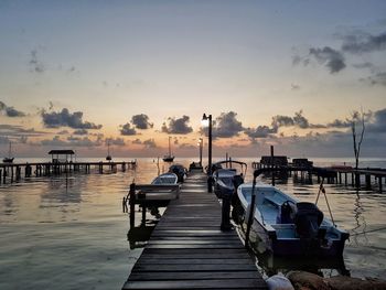 Pier over sea against sky during sunset