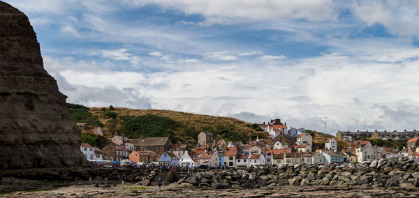 Houses in town against cloudy sky