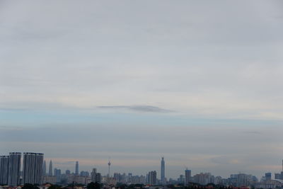 Modern buildings in city against sky during sunset