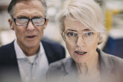 Close-up of serious business people wearing eyeglasses at industry