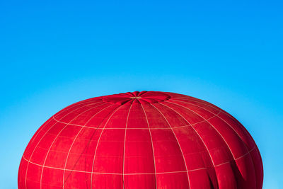 Low angle view of hot air balloons against clear blue sky