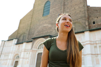 Low angle view of woman standing against building
