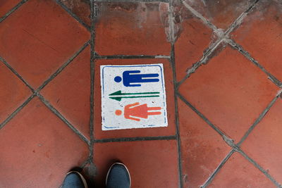 Low section of person standing on tiled floor