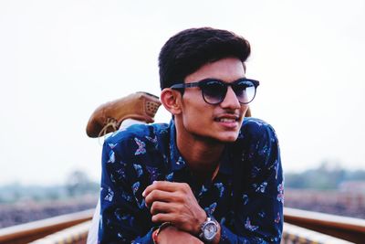 Young man wearing sunglasses against clear sky