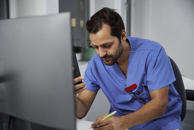 Male doctor using smart phone in office