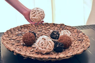 Close-up of hand holding ice cream in basket on table