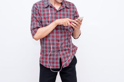 Midsection of man using mobile phone against white background