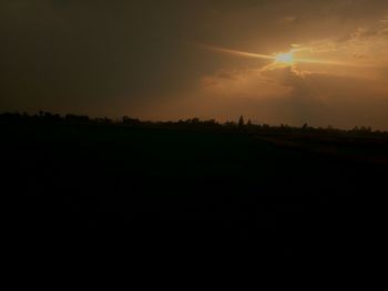 Scenic view of silhouette field against sky during sunset