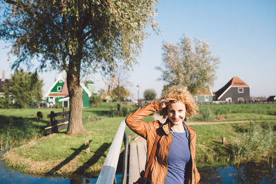 Portrait of smiling woman in city against sky