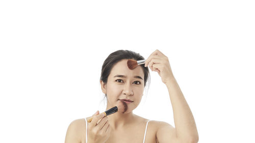 Portrait of a young woman against white background