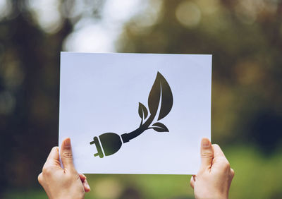 Midsection of person holding paper against blurred background