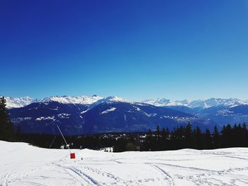 Scenic view of snowcapped mountains against clear blue sky