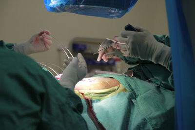 Midsection of surgeons operating patient at hospital