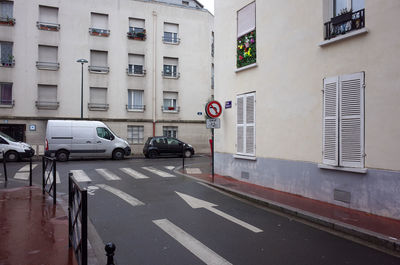 Road sign on street against buildings in city