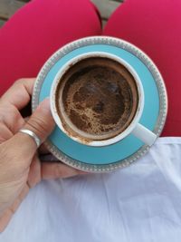 Midsection of person holding coffee cup on table