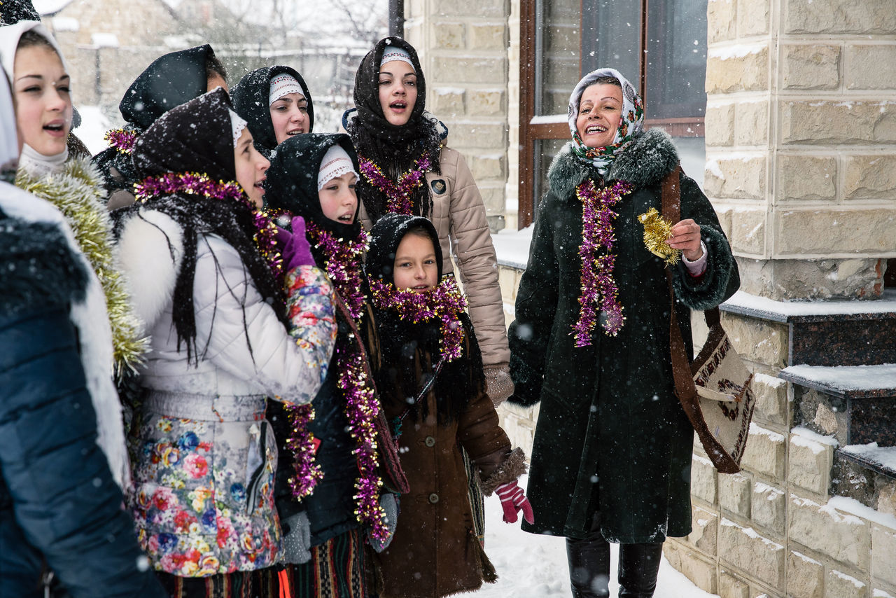 winter, group of people, warm clothing, women, adult, clothing, young adult, architecture, smiling, standing, real people, snow, cold temperature, happiness, emotion, three quarter length, young women, men, building exterior, togetherness, mature men, outdoors