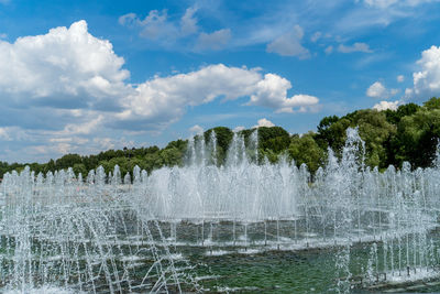 Water splashing in fountain against sky