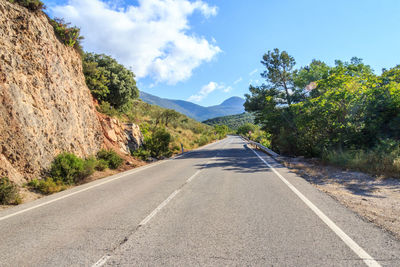 Road amidst trees against sky