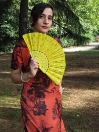 Portrait of beautiful woman standing against plants