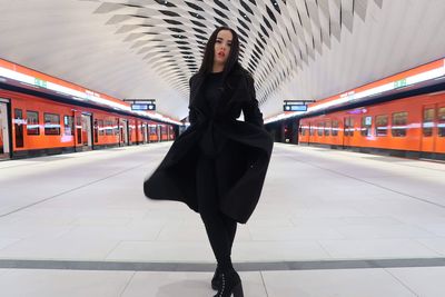 Low section of woman standing in subway