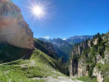 Scenic view of mountains against blue sky on sunny day