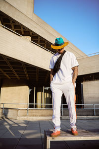 Man wearing hat while standing against building