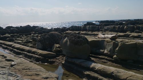 Panoramic view of rocks on beach against sky