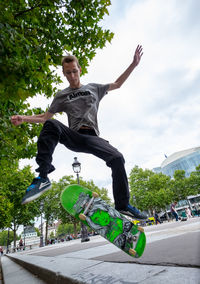 Young man skateboarding on skateboard against sky