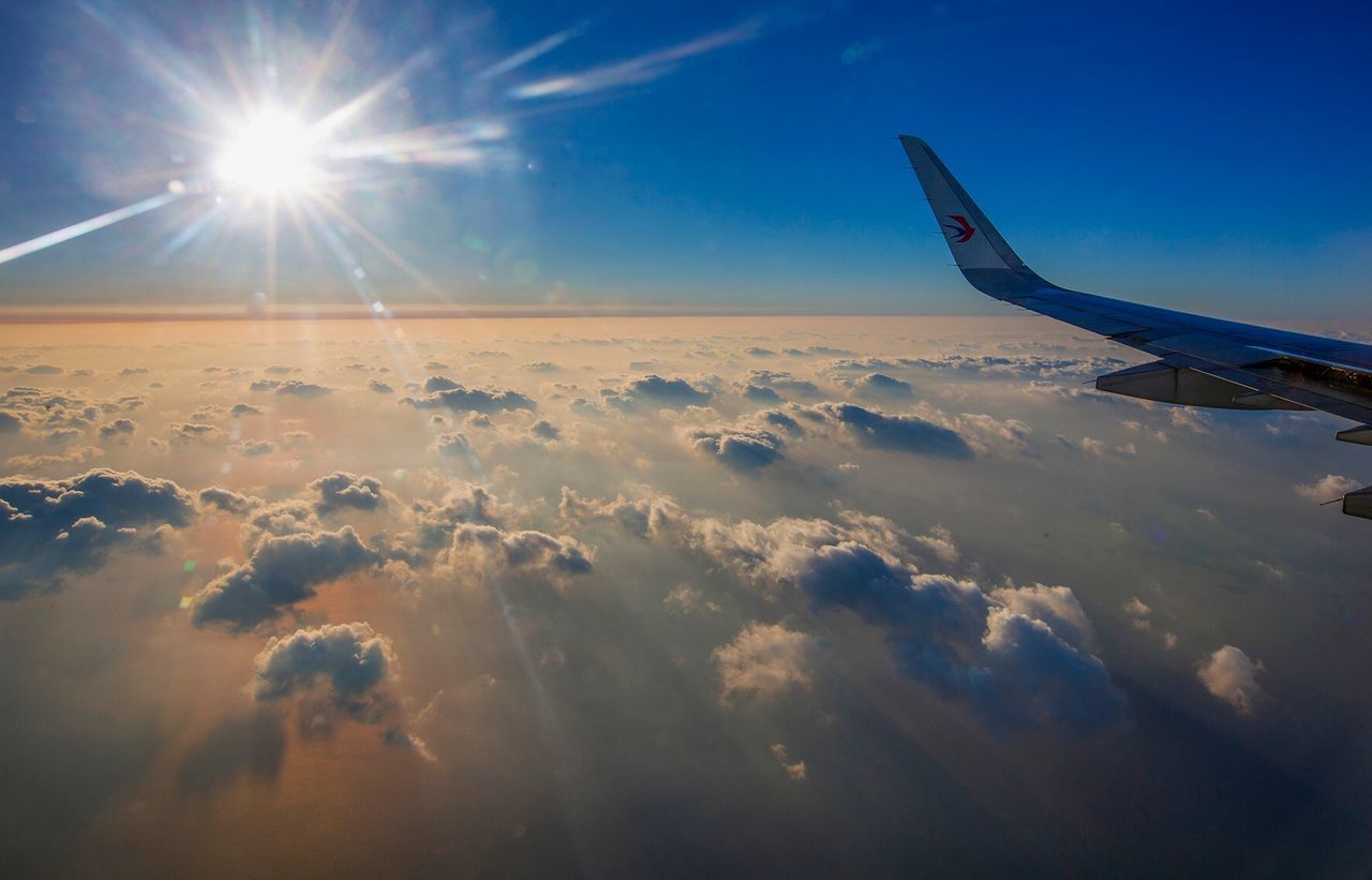 VIEW OF AIRPLANE WING OVER CLOUDS