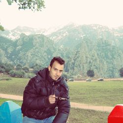 Portrait of young man against mountains