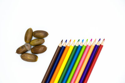 High angle view of multi colored pencils against white background