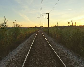 Railroad track against sky during sunset