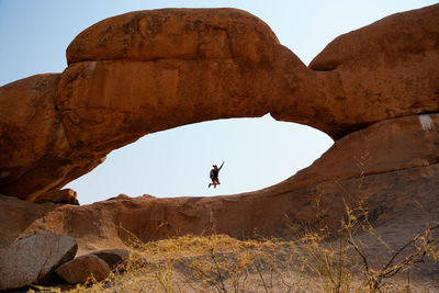 Rear view of man standing on rock formations