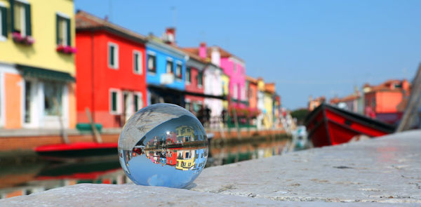 Close-up of umbrella by canal against buildings in city