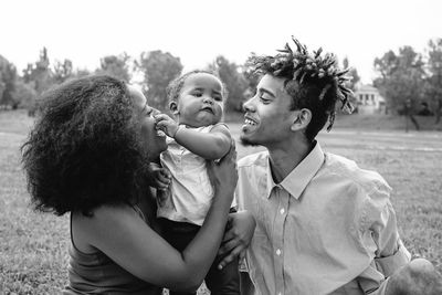 Happy parents playing with cute daughter in park