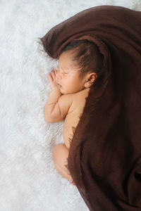 High angle view of baby sleeping on bed